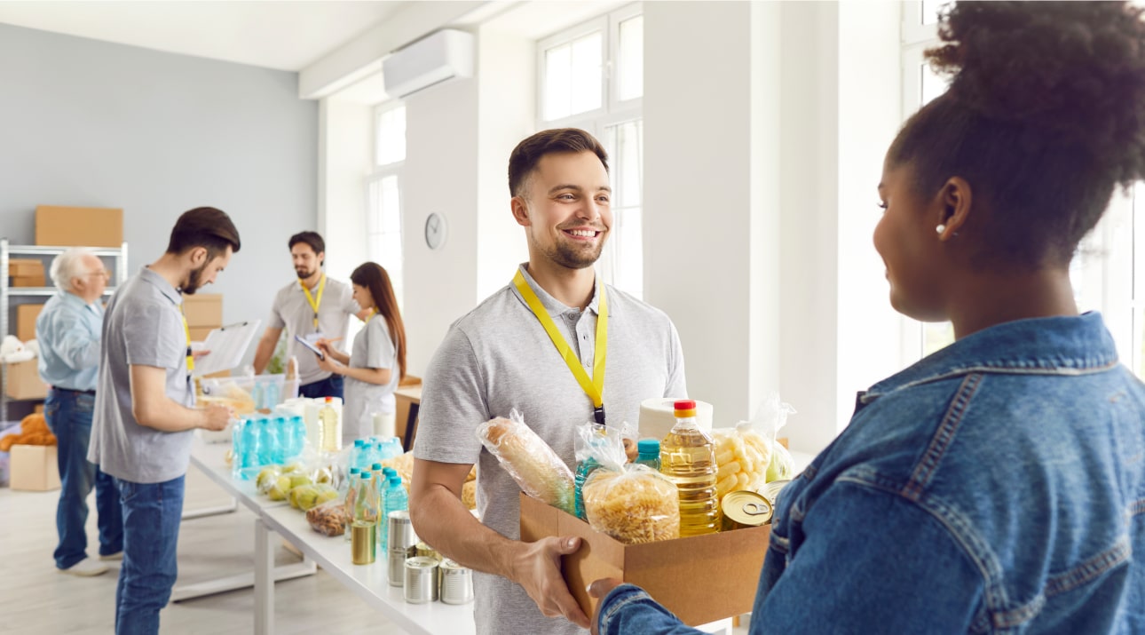 Family receiving groceries from a community food bank to help counter effects felt by rising food costs due to inflation.